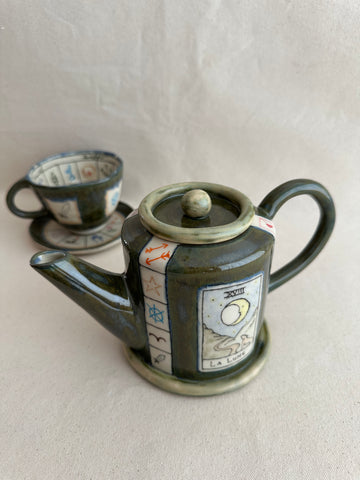 Théière "Il suffit de demander" avec tasse assortie.